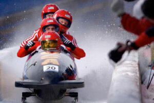 Bob sled team in red reflecting team development through coaching lawyers in law firms