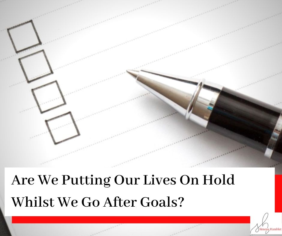 Checklist with a pen and the title Are We Putting Our Lives On Hold Whilst We Go After Goals?