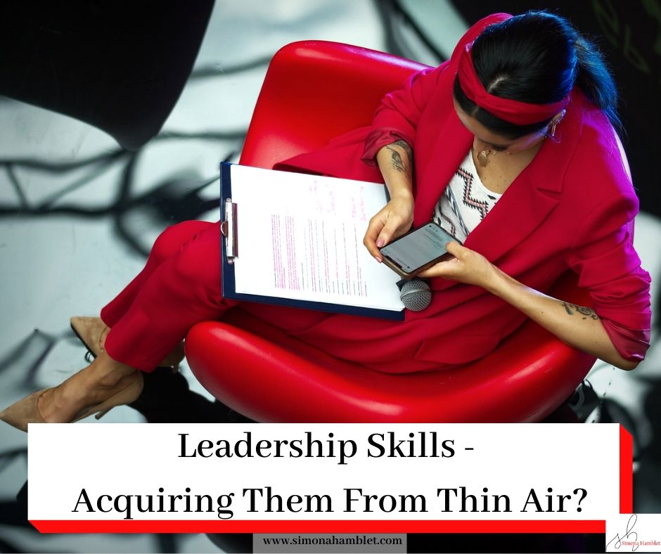 Woman in red sat in a chair with a clipboard and a mobile phone along with the article title Leadership Skills - Acquiring Them From Thin Air?