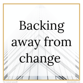 An image of a law firm building in white with the words 'backing away from change' on the front.